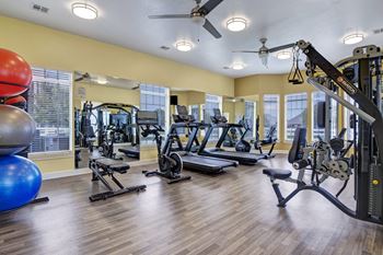 a gym with weights and exercise equipment and windows